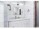 Bathroom vanity with white cabinets, a marble countertop, and modern fixtures at 6505 W Hampden Ave, Lakewood, CO 80227