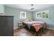 Comfortable bedroom with wood floors, two windows, and warm-toned bedding at 6505 W Hampden Ave, Lakewood, CO 80227