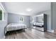 Bright bedroom featuring two windows, hardwood floors, and a mirrored wardrobe closet at 6505 W Hampden Ave, Lakewood, CO 80227