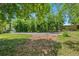 View of the driveway leading to the property, surrounded by lush trees and landscaping at 6505 W Hampden Ave, Lakewood, CO 80227