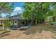 Home exterior with lush trees, a detached garage, and spacious deck at 6505 W Hampden Ave, Lakewood, CO 80227