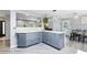 Bright kitchen featuring gray cabinets, marbled countertops, and hardwood floors at 6505 W Hampden Ave, Lakewood, CO 80227