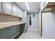 Spacious laundry room with custom cabinets, ample counter space, and modern gray finishes at 6505 W Hampden Ave, Lakewood, CO 80227
