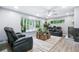 Cozy living room with large windows, comfortable seating, and a brick fireplace feature at 6505 W Hampden Ave, Lakewood, CO 80227