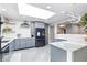 Modern kitchen with stainless steel appliances, updated cabinetry, and stylish lighting fixtures at 6505 W Hampden Ave, Lakewood, CO 80227