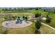 Overhead view of a well-maintained playground with various play structures in a green, grassy park setting at 11427 King Way, Westminster, CO 80031