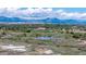 Expansive aerial view showcasing a park with ponds, green spaces, and a backdrop of mountains at 11427 King Way, Westminster, CO 80031