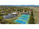 Stunning aerial image of the property amenities including tennis courts, a pool, and a pond at 11427 King Way, Westminster, CO 80031