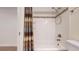 Well-lit bathroom with a tub, shower, neutral tiling, and a decorative shower curtain at 11427 King Way, Westminster, CO 80031