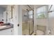 Bathroom featuring a glass-enclosed shower, vanity with solid surface countertops and window at 11427 King Way, Westminster, CO 80031