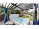Backyard hot tub under a pergola with privacy curtains, surrounded by green lawn at 11427 King Way, Westminster, CO 80031