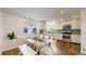 Well-lit kitchen and dining area with wood floors, white cabinets, and a large window for natural light at 11427 King Way, Westminster, CO 80031