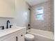 Modern bathroom featuring sleek grey tiled walls, bright window, and black bathroom fixtures at 5153 Scranton St, Denver, CO 80239