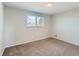 Bright bedroom with neutral walls, plush carpeting, and a large window overlooking the yard at 5153 Scranton St, Denver, CO 80239