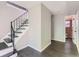 Hallway featuring a staircase with black railings and an open door to a bathroom with brick wall at 5153 Scranton St, Denver, CO 80239