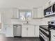 Updated kitchen featuring white cabinets, stainless steel appliances, bright lighting, and quartz countertops at 5153 Scranton St, Denver, CO 80239