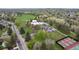 A high-angle view shows a neighborhood with a community center, pool, park, tennis courts, and various amenities at 2140 S Ash St # 105, Denver, CO 80222