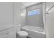 Bright bathroom featuring a white tub, light gray tile, and a convenient storage cabinet at 2140 S Ash St # 105, Denver, CO 80222