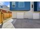 Modern townhome exterior with gray siding, a garage door, and a small front yard at 2140 S Ash St # 105, Denver, CO 80222