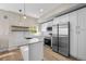 Bright kitchen features white cabinets, stainless steel appliances, quartz countertops, and wood-look floors at 2140 S Ash St # 105, Denver, CO 80222