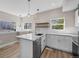 Bright kitchen with white cabinets, quartz countertops, stainless steel appliances, and stylish pendant lighting at 2140 S Ash St # 105, Denver, CO 80222