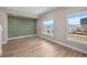 Bright living room with wood floors, accent wall, and large windows offering city views at 2140 S Ash St # 105, Denver, CO 80222