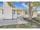 A close-up of the front entrance with a white door, landscaping, and beautiful trees at 3561 W 131St Ave, Broomfield, CO 80020