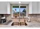 Close up of a modern kitchen sink with stainless fixtures, light countertops and cardinal art at 3561 W 131St Ave, Broomfield, CO 80020
