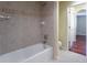 Bathroom features a tiled bathtub and shower combination, plus an open doorway leading into the next room at 14033 E Whitaker Dr, Aurora, CO 80015