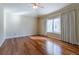 Neutral bedroom featuring hardwood floors, a ceiling fan, and curtained window at 14033 E Whitaker Dr, Aurora, CO 80015