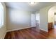 Bedroom features hardwood floors, a window, access to a bathroom, and a doorway leading to hallway at 14033 E Whitaker Dr, Aurora, CO 80015