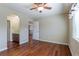 Bedroom featuring a ceiling fan, an ensuite bathroom, neutral walls, and hardwood floors at 14033 E Whitaker Dr, Aurora, CO 80015