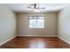 Bedroom featuring a ceiling fan and light fixture, neutral walls, hardwood floors, and a bright window at 14033 E Whitaker Dr, Aurora, CO 80015