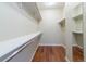 Walk-in closet with built-in shelving and hardwood floors at 14033 E Whitaker Dr, Aurora, CO 80015