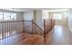 Bright hallway featuring hardwood floors, wood banister and staircase, and natural light from multiple windows at 14033 E Whitaker Dr, Aurora, CO 80015