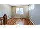 Bright hallway area featuring hardwood floors, natural light from a window, and neutral walls at 14033 E Whitaker Dr, Aurora, CO 80015