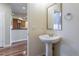 Powder room featuring a pedestal sink, mirror, and access to other parts of the house at 14033 E Whitaker Dr, Aurora, CO 80015