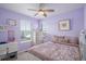 Charming bedroom with lavender walls, a ceiling fan, and bright natural light through the windows at 14693 E Crestridge Dr, Aurora, CO 80015