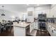 Bright kitchen featuring stainless steel appliances, white cabinets, and island overlooking the living area at 14693 E Crestridge Dr, Aurora, CO 80015