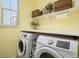 Well-organized laundry room with side-by-side washer and dryer and shelving for storage at 14693 E Crestridge Dr, Aurora, CO 80015