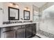 Bathroom featuring dual sinks, modern lighting, and a glass shower at 9523 Sherrelwood Ln, Highlands Ranch, CO 80126