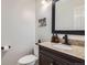 Charming powder room featuring granite countertop, black faucet, and convenient toilet paper holder at 9523 Sherrelwood Ln, Highlands Ranch, CO 80126