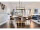 Dining room with a large wooden table, stylish chairs, hardwood floors, and natural lighting at 9523 Sherrelwood Ln, Highlands Ranch, CO 80126
