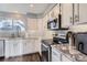 Modern kitchen with white cabinets, stainless steel appliances and marbled countertops at 9523 Sherrelwood Ln, Highlands Ranch, CO 80126