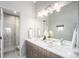 Bathroom with dual vanity, large mirror, modern lighting, and a glass enclosed shower at 4144 Tennyson St # 212, Denver, CO 80212