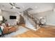 Open-concept living area with staircase, hardwood floors, modern decor, and TV at 4144 Tennyson St # 212, Denver, CO 80212