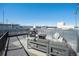 Roof deck with outdoor seating, grill, fire pit, and overhead string lights at 4144 Tennyson St # 212, Denver, CO 80212