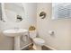 Charming powder room featuring a pedestal sink, decorative mirror, and neutral color palette at 19121 E 65Th Ave, Denver, CO 80249