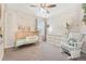 Cozy Bedroom featuring a crib, a dresser, and a glider chair with whimsical decor at 19121 E 65Th Ave, Denver, CO 80249