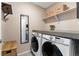 Laundry room showcasing front loading washer and dryer with folding counter and shelving at 19121 E 65Th Ave, Denver, CO 80249